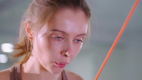 Close Up of Female Athlete Lifting Weights with Intense Focus in Gym