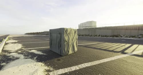 Mysterious Wrapped Object in Empty Lot at Sunrise By the Coast