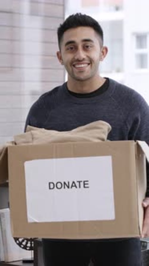 Face, man and clothes in donation box in home for non profit, portrait and community care