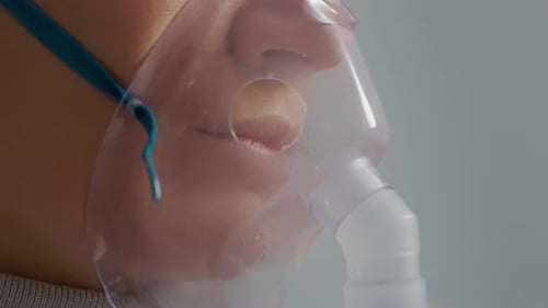 Gros plan d'une femme utilisant un nébuliseur pour traiter ses problèmes respiratoires à la maison