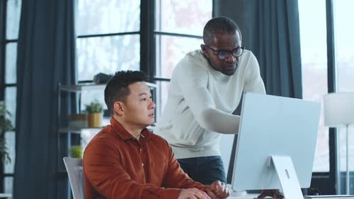 Men Collaborating and Working Together at Computer