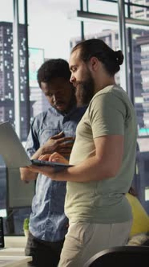 Vertical Video Developer and Colleague Checking Code on Notebook Doing Brainstorming