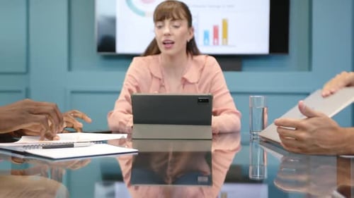 Meeting in office, woman using tablet and smiling, diverse colleagues discussing work