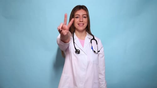Smiling Young Woman Doctor Making Peace Sign
