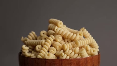 Dry Rotini Pasta in a Wooden Bowl