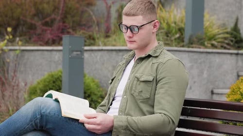 Typ, der sich mit einem Buch an der frischen Luft entspannt