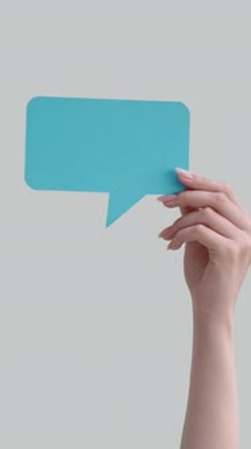 Hand Holding a Blue Speech Bubble Shape
