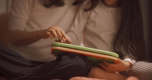 Mother and Daughter Using Tablet Device Together Indoors