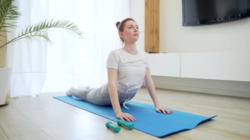 Woman Doing Yoga Exercise on Mat Indoors