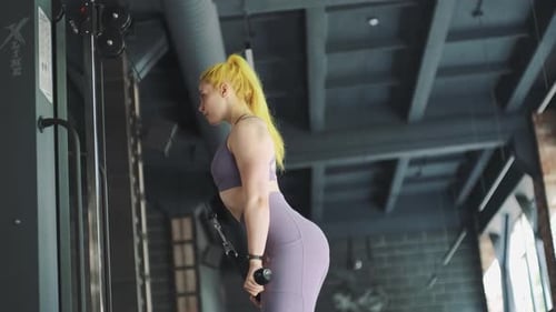 Gorgeous Female Professional Bodybuilder Doing Workout Exercises in Gym