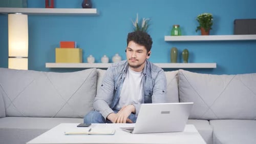Man listening to music with headphones is unhappy and sad.