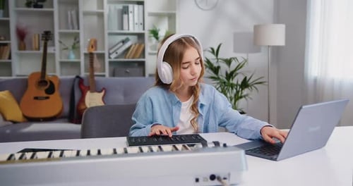 Girl Plays Electronic Keyboard with Computer at Home