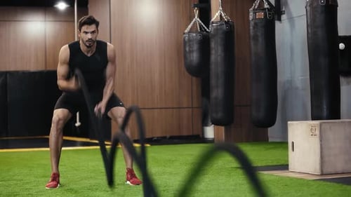 bearded man working out with suspension straps