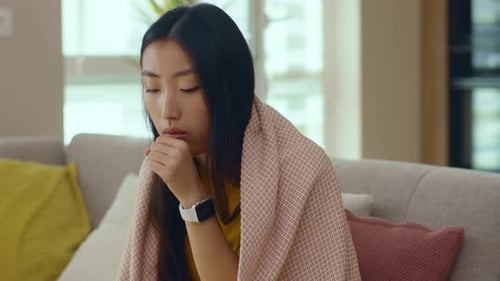 Sick Woman Coughing While Resting on Couch