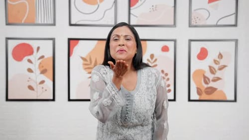 Woman Smiling and Blowing a Kiss Indoors
