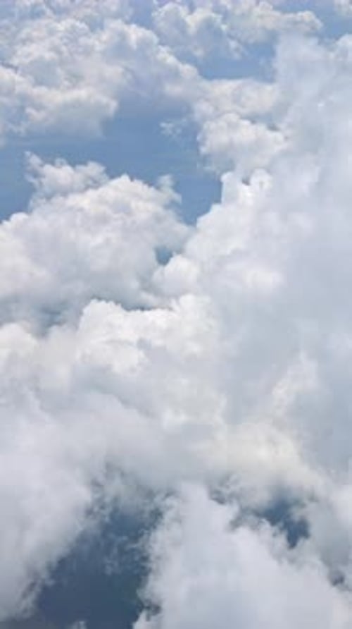 View of the clouds from an airplane window. Vertical