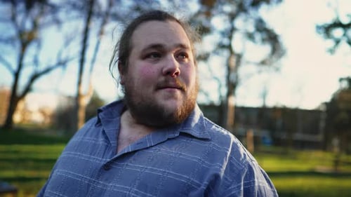 Happy young man in 20s strolling outdoors in sunny beautiful day. Happiness concept