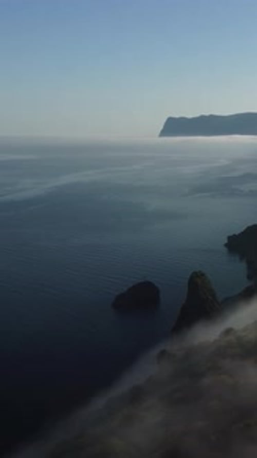 Vertikale Luftaufnahme der Meereslandschaft mit kristallklarem, ruhigem azurblauem Meer und felsigen Ufern Eine wunderschöne