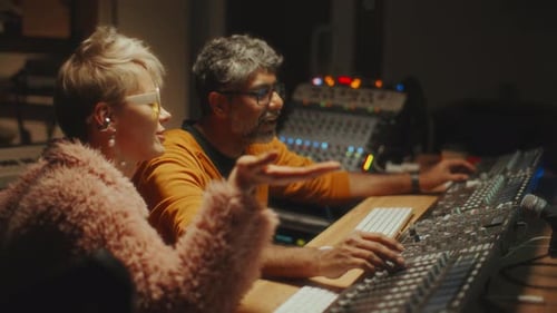 Sound Engineer and Female Musician Collaborating in Recording Studio