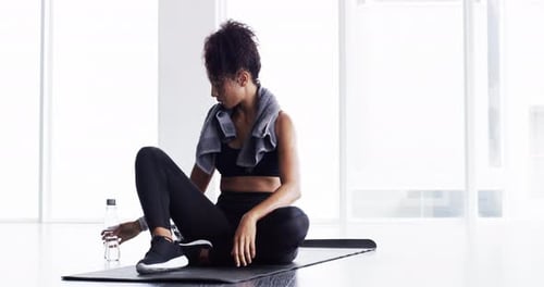 Woman drinking, water bottle with fitness and relax after workout, sport and tired with hydration