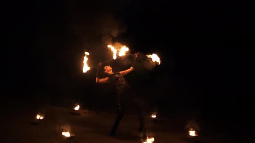 Woman Juggling Fire Torches at Nighttime Performance