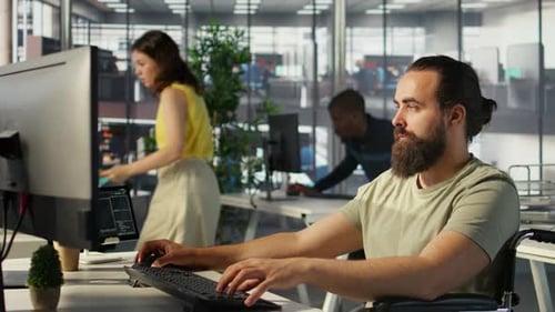 Man Using Computer in Wheelchair at Modern Office