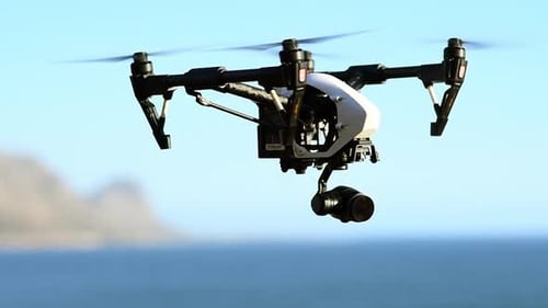Drone, camera and flight of photography technology at the beach filming sea landscape with water