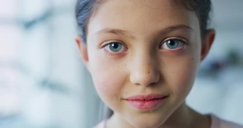 Close up portrait of a little girl with blue eyes looking in the camera on daylight background. Sh