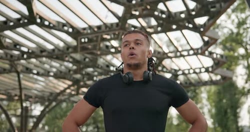 Tired African American Athlete Restores Breathing and Rests After Jogging Outdoors