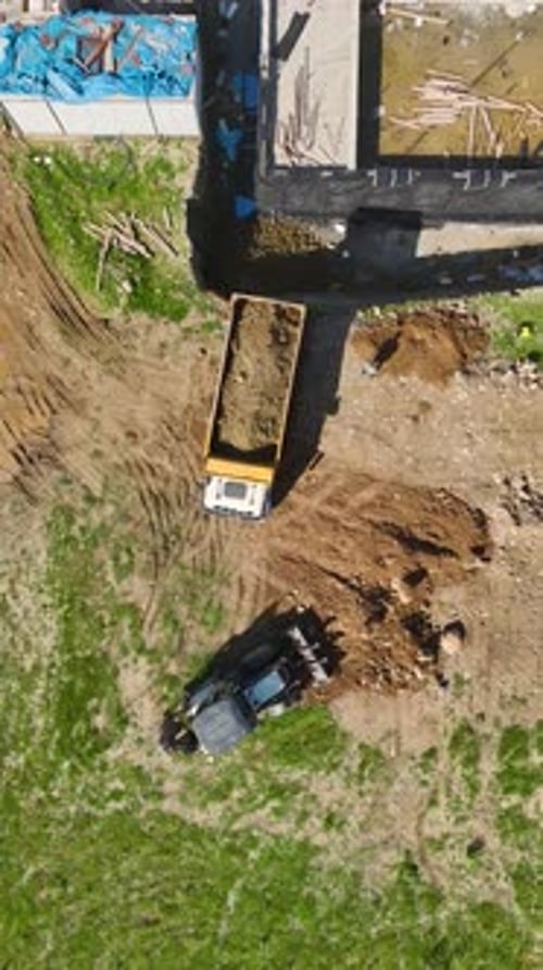 Vertical Video Timelapse of a Busy Construction Site with Builders and Machines Working Together