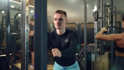 Medium Shot of Handsome Man Doing Exercises on Vertical Row Machine in Gym