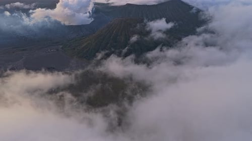 Aerial view of mount bromo volcano emerging from clouds at sunrise