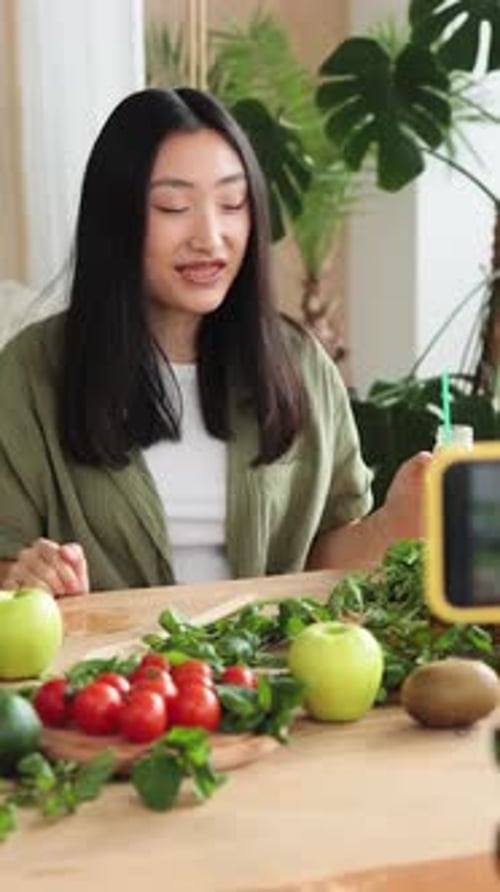 Enthusiastic woman presenting green smoothie to camera