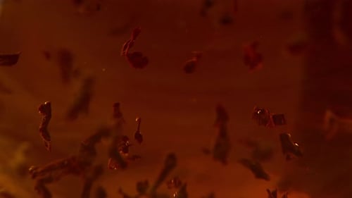 Tea Leaves Swirling in Amber Liquid