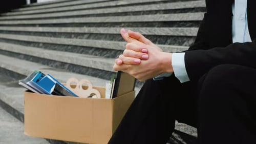 Unemployed Person Sitting on Steps by Box