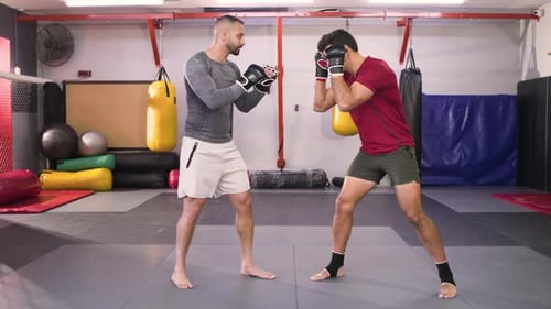 Verschiedene männliche Boxer treten im Kampfsport-Fitnessstudio auf die Matte und geben den linken Jab für die Trainingsübung ab
