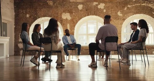 Group Therapy Meeting for Adults in a Brick Room Participants in Group Therapy Sit in a Circle and