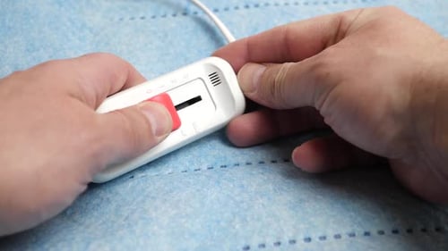 K120. A man unfolds an electric sheet. The concept of warmth and comfort in the house.