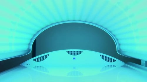 Inside bright blue tanning booth with lid closed and switched on, zooming out