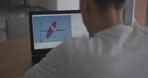 Designer macht Modell im Programm auf Laptop am Holztisch