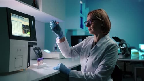 Scientist Analyzing Blood Sample in High-Tech Lab