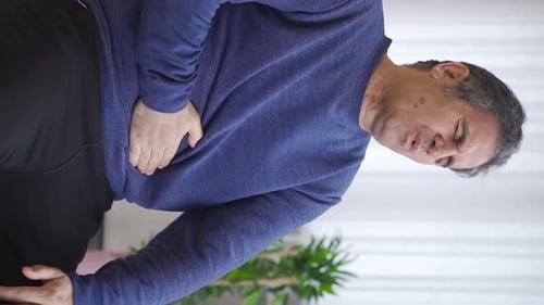 Man Holding Back and Abdomen in Pain