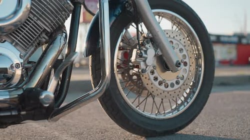 Close Up of Motorcycle Front Wheel with Rider Leg on Bike Stand