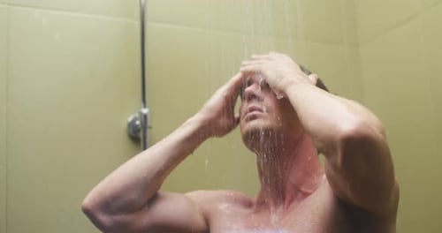 Young Man Washes Out Shampoo From Black Hair in Hotel Shower