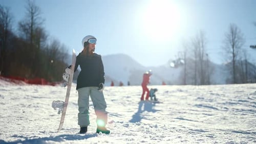 Woman Snowboarding on Mountain in Winter Sunlight