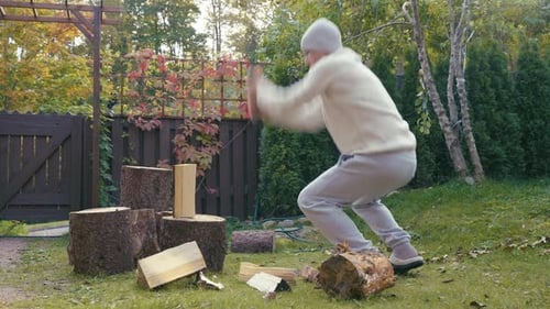 A Middleaged Man is Chopping Firewood