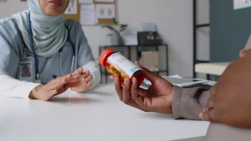 Muslim Obstetrician Prescribing Medication to Expectant Black Woman in Clinic