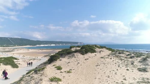 Aerial view flying over natural dunes and beach of Los Canos de Meca in Spain