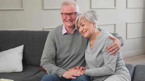 Senior Couple Embracing on Couch at Home
