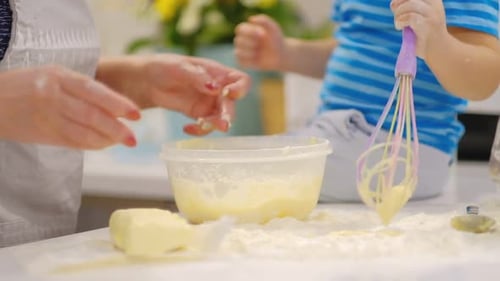 Child and Adult Baking Together in Kitchen